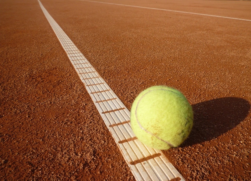 Tennisbal op de lijn van een gravelbaan