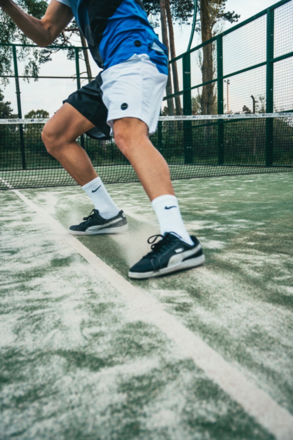 Padelspeler die over een groene baan sprint
